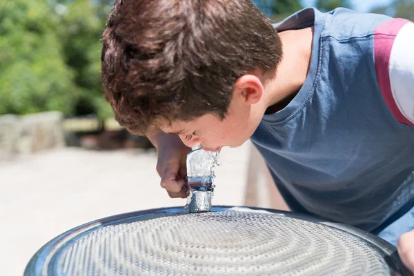 Garçon à la fontaine d'eau profiter d'une boisson fraîche — Photo