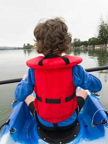 Smartphone bild ung pojke i röda flytväst kajakpaddling — Stockfoto