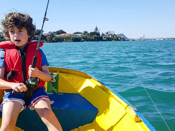 Kid fiske från liten jolle på Tauranga Harbour. — Stockfoto