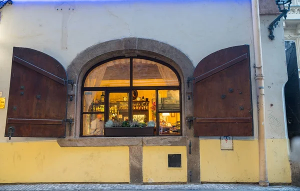 Estilo tradicional retauarant ventana con persianas abiertas por la noche . — Foto de Stock