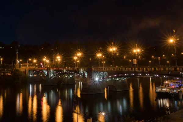 Oświetlony most na Wełtawie z odbicia w spokoju — Zdjęcie stockowe