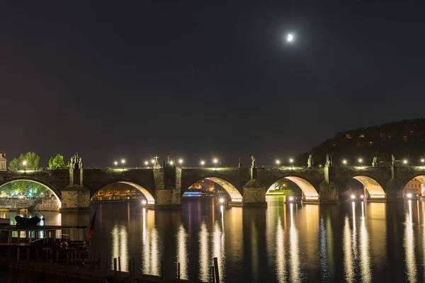Księżyc w ciemną noc niebo nad podświetlany most łuki i odzwie — Zdjęcie stockowe