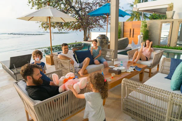 Jóvenes familias modernas sentadas afuera disfrutando de una y otra — Foto de Stock