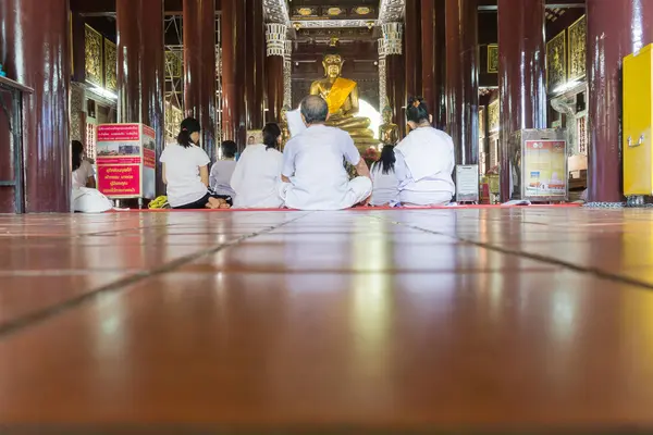 Persone vestite di bianco sul pavimento del tempio buddista in devozione — Foto Stock