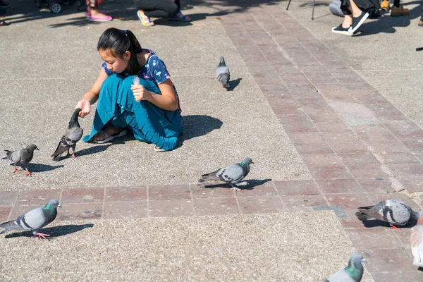Азіатський жінка в Синє плаття crouches годування голубів у Pratu Tha — стокове фото