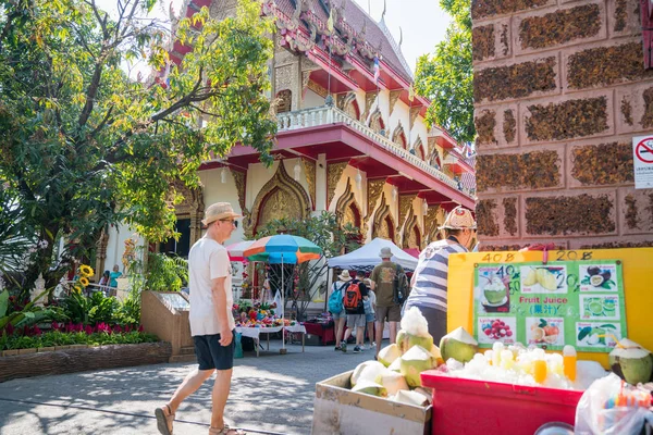 As pessoas passam por barraca de coco e templo budista na rua da cidade — Fotografia de Stock