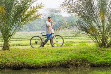 Kırsal İşçi geldiğinde Bisiklet wheeling ve sigara alanları bir lo