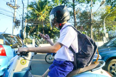 Cep telefonu kullaranarak motosiklet üzerinde kişi