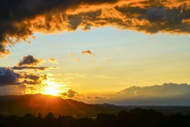 Karanlık ateşli günbatımı Avrupa peyzaj f üzerinde bulutlar.