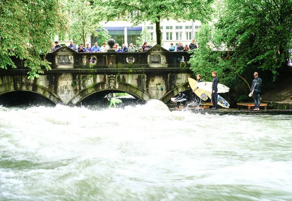 Surfistas fluviais no rio Eisbach no meio da cidade europeia . — Fotografia de Stock