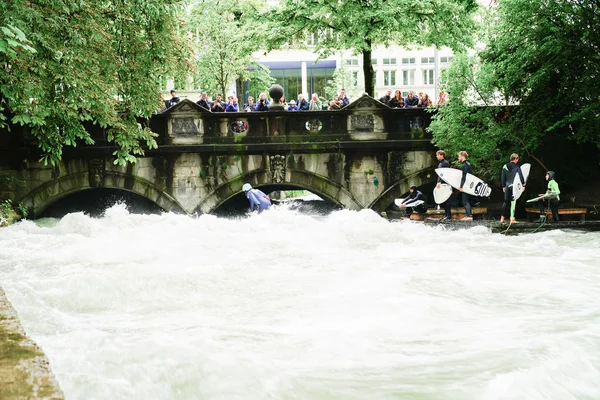 Surfistas fluviais no rio Eisbach no meio da cidade europeia . — Fotografia de Stock