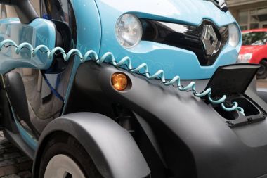 Parlak mavi ve siyah mikro-araba Renault Stut üzerinde şarj Twizy