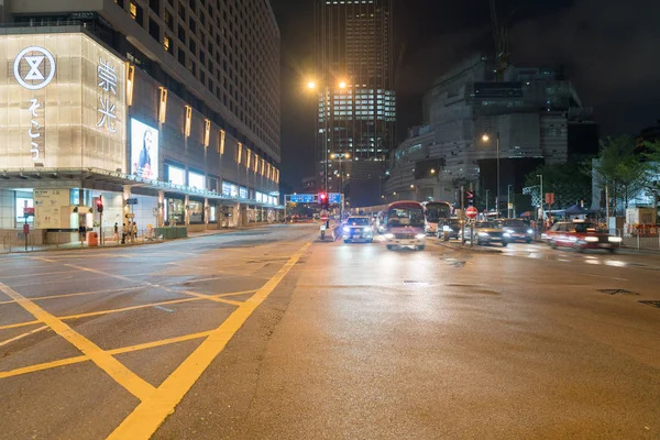 Intersección de la ciudad bajo luces nocturnas a medida que los coches y autobuses pasan en z —  Fotos de Stock