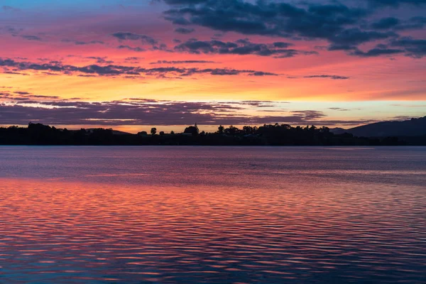 El intenso amanecer refleja rojo en el agua — Foto de Stock