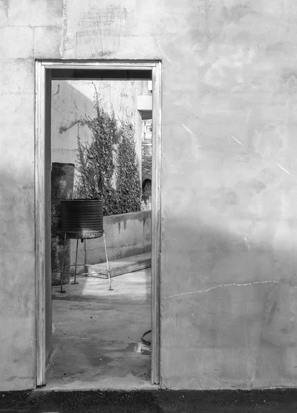Дверь сквозь ржавую стену во внутренний дворик с барбекю — стоковое фото