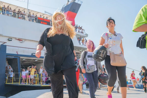 Люди приходят и уходят с парома Греческого острова на пристани — стоковое фото