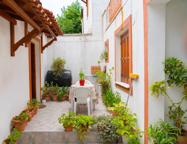 Güneşli köşe saksı, masa ve sandalyelerle dolu..