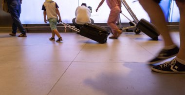 Bulanık insanların bacakları yürür ve bavullarını Ilumina 'dan geçirir.