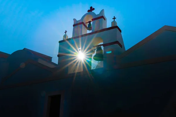 Traditionell grekisk kyrka klocktorn tillbaka upplyst av solen med lins fl — Stockfoto