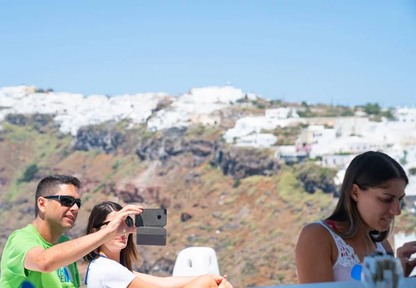 Pareja joven posando juntos para selfie con isla griega blanca — Foto de Stock