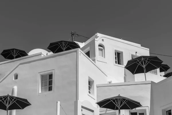 Witte muren onder oneven hoeken met ramen en zwarte parasols. — Stockfoto
