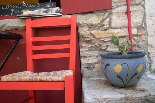 Красное кресло и зеленый кактус — стоковое фото