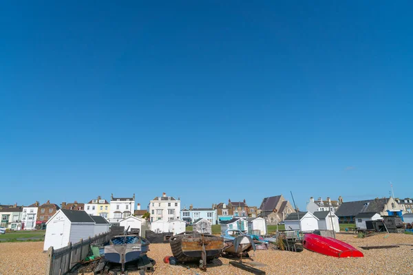 Typical British coastal town with boats pulled up on stony beach — 스톡 사진