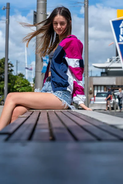 Adolescente sentada no banco ao ar livre — Fotografia de Stock