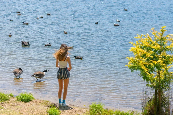 若い女性が立って水の端に移動するのを踏んで. — ストック写真