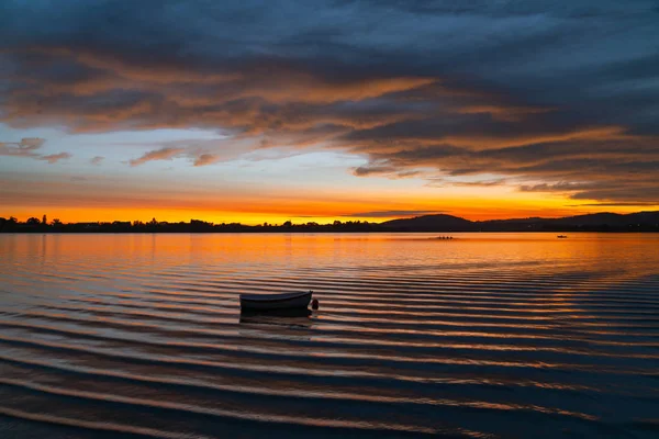 Sanft verschwommenes kleines Boot schaukelt bei Sonnenaufgang in der Bucht — Stockfoto