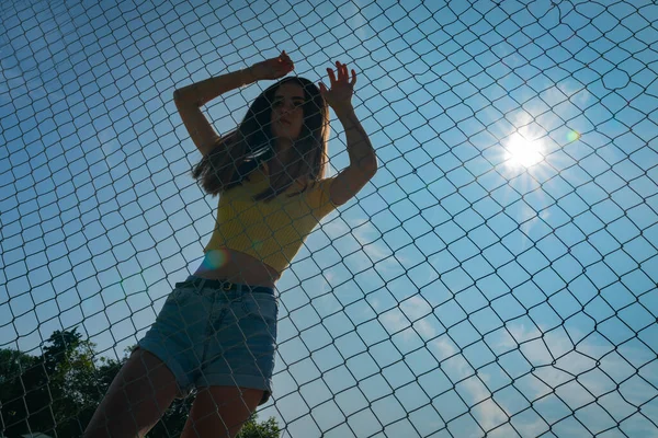 Adolescente menina no topo amarelo de pé com os braços levantados atrás chai — Fotografia de Stock