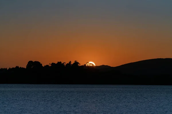 Sonnenaufgänge nur über fernen Hügeln — Stockfoto