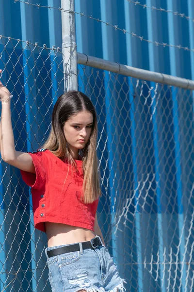 Op zoek verveeld, jonge vrouw in trendy kleding stand by industr — Stockfoto