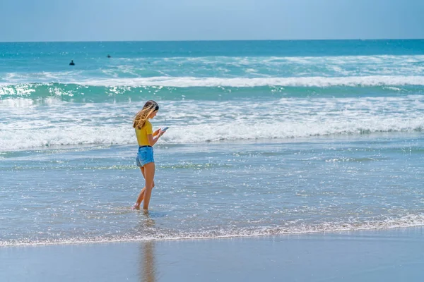 Teenage girl standing on beach — Stock Photo, Image