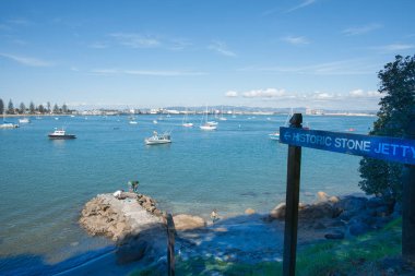 Tauranga Yeni Zelanda - 13 Nisan 2013; Tarihsel Taş Jetty 'den çocuklar ve ebeveynler balıkçılık ve Pilot Koyu' ndaki Mount üssünde plaj.