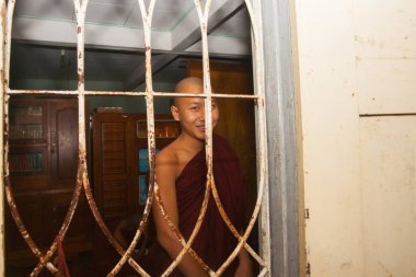 Bagan Myanmar - 30 Ekim 2013; Pencere arkasında bakan ve gülümseyen Budist keşiş