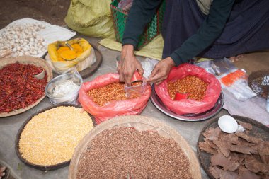 Inle Gölü Myanmar - 3 Kasım 2013; Inle Gölü 'ndeki yüzen pazarlarda ürünlerini ve mallarını satarak tahılı torbaya koymak.