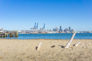 Auckland, Yeni Zelanda - 22 Mayıs 2020; Devonport iskelesinin yanındaki sahilden Auckland limanına bakın.