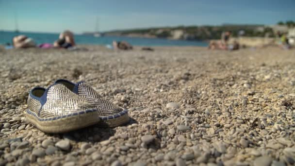 Пляжні Черевики Розслабляються Пляжі Роккі Самотня Пара Капців Сидить Скелястому — стокове відео