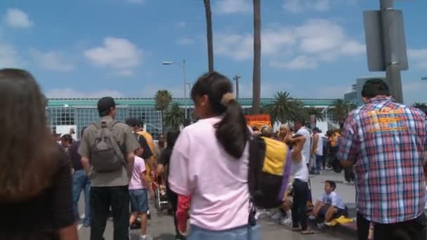 群衆の中を歩く Laのダウンタウンにあるステープルズセンターの前にある混雑した通りで レイカーズチャンピオンシップのパレードが通過するのを待っています 2010年6月21日カリフォルニア州ロサンゼルス — ストック動画