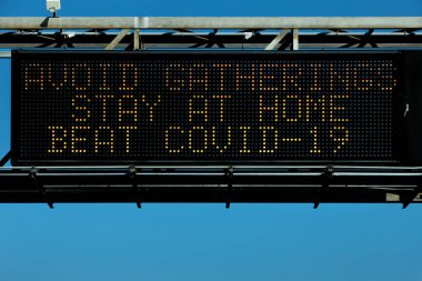 Los Angeles, Kaliforniya 'da bir değişken-mesaj işareti sakinleri AVOID GATHERINGS, BEAT COVID-19.