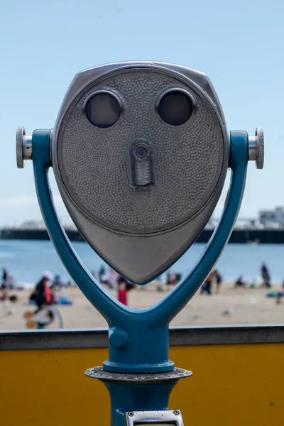 Vintage Beach Binoculars. An old metal coin operated set of stationary binoculars for tourists over looking a beach.