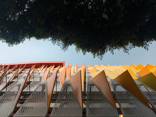 Renkli Mimarlık Geçmişi. Parlak, kalça, renk dolu, canlı metalik yüzgeç benzeri elementler binanın yan tarafında asılı..