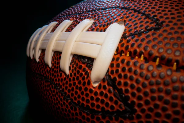 Dikişli bağcıklara, desenli cilde ve Amerikan futbolunun gamzelerine geniş açılı makro yakın çekim..