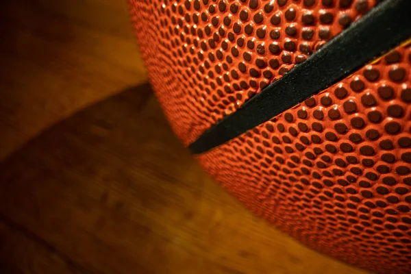Son derece geniş açılı makro yakın çekim bir basketbol kaburgası sert ahşap zemin arka planı.