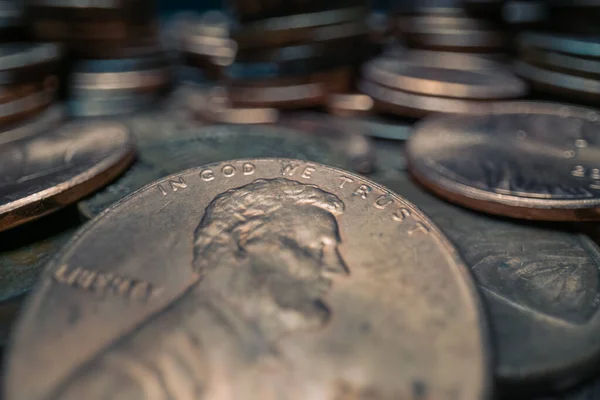 Shiny Penny, IN GOD WE TRUST. Wide macro lens extreme close up (ECU) of some change in a pile of copper US pennies.