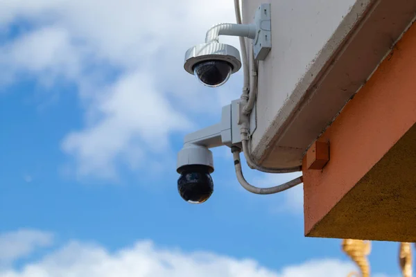 安保摄像头 安装在大楼角落的两台圆顶监控摄像头 免版税图库图片