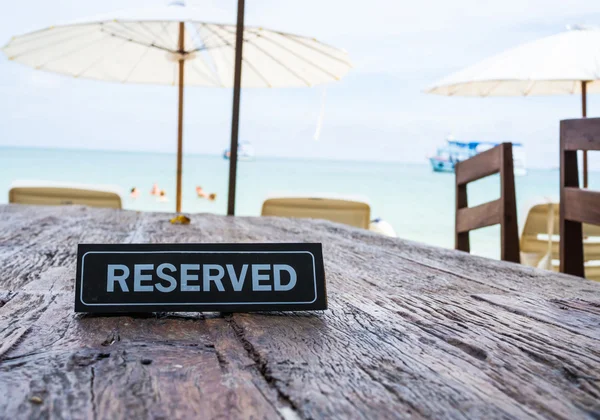 Rezervovaná banner na restauraci u stolu, beach pozadí — Stock fotografie