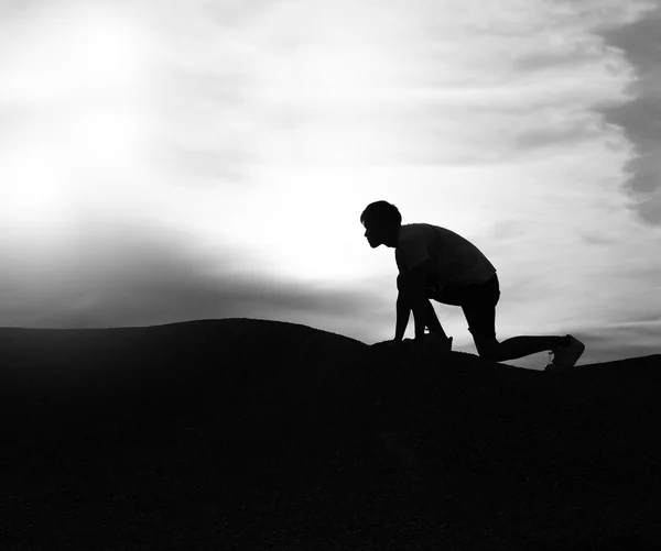Preto e branco, silhueta de homem escalando montanha com dramat — Fotografia de Stock