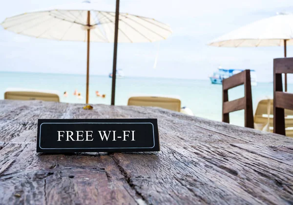 Banner Wi-Fi gratuit pe masa de restaurant, fundal pe plajă — Fotografie, imagine de stoc